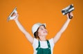 success. teen girl use putty knife. builder in coveralls and helmet with spatula. kid repair wall with spackling paste Royalty Free Stock Photo