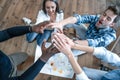 Success. Top view of young modern people in smart casual wear holding hands on top of one another in a symbol of unity while Royalty Free Stock Photo