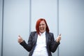 Success! Victory! Happy successful red-haired girl boss, businesswoman in a suit emotionally celebrates, with space for text and