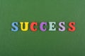 SUCCESS word on green background composed from colorful abc alphabet block wooden letters, copy space for ad text. Learning Royalty Free Stock Photo