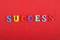 SUCCESS word on red background composed from colorful abc alphabet block wooden letters, copy space for ad text. Learning english Royalty Free Stock Photo