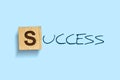 Success. Words written on a wooden block. Blue background. Isolated. Business