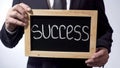 Success written on blackboard, businessman holding sign, business concept Royalty Free Stock Photo
