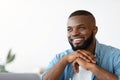 Successful African American freelancer guy sitting at desk with laptop looking aside Royalty Free Stock Photo