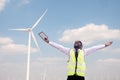 Successful african engineer windmills standing and hoding tablet with wind turbine in background