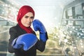 Successful and aggressive young muslimah businesswomen with boxing glove over abstract double exposure background Royalty Free Stock Photo