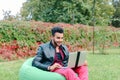 Successful Arabic Young Businessman Sits With Laptop in Chair, Stares at Laptop Screen, Raises Hands, Making Hand Royalty Free Stock Photo