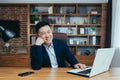 Successful asian broker businessman looks at camera and smiles, man at work sitting at table in classic office Royalty Free Stock Photo