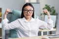Successful Asian business woman looking at the camera and holding her hands up, a gesture of super power and success, an Royalty Free Stock Photo