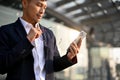 Successful Asian businessman is holding his glasses and looking at his phone screen Royalty Free Stock Photo