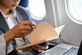 Successful Asian businessman reading a book during the flight for his business trip. cropped Royalty Free Stock Photo