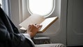 Successful Asian businessman reading a book during the flight for his business trip Royalty Free Stock Photo