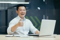 Successful asian investor businessman smiling and looking at camera showing thumb up, man working in modern office Royalty Free Stock Photo
