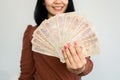 Successful Asian woman hand showing Thai money banknotes ,investment and earning conce
