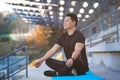 Successful athlete sitting in lotus position in the morning meditating, asian man looking at camera and smiling holding thumbs up Royalty Free Stock Photo