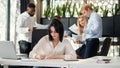 Young exuberant female office worker looking at camera with lovely smile at her workplace in meeting room