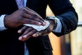 Successful and beautiful American afro man in a dark business suit in a white shirt using wet wipes Royalty Free Stock Photo