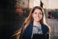 Successful beautiful young business woman is smiling on the background of buildings and holding a tablet computer. Royalty Free Stock Photo