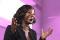 Successful black afro American business woman with headset speaking in auditorium at corporate training event or seminar giving Royalty Free Stock Photo