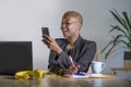 Successful black afro American business woman working at modern office with mobile phone writing notes on notepad Royalty Free Stock Photo