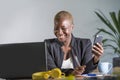 Successful black afro American business woman working at modern office with mobile phone writing notes on notepad Royalty Free Stock Photo