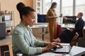 Successful black businesswoman using laptop in office with all female team Royalty Free Stock Photo