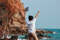 Successful business concept. Cheering Asian man with laptop raising hands at sea shore. Royalty Free Stock Photo