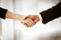Successful business concept. Young businesswoman and businessman shake hands closeup after signing partnership