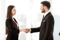 Successful business concept. Young businesswoman and businessman shake hands after signing partnership cooperation Royalty Free Stock Photo