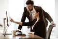 Successful business concept. Young businesswoman sits at the office table busy working on computer. Happy smiling Royalty Free Stock Photo