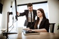 Successful business concept. Young businesswoman sits at the office table busy working on computer. Happy smiling Royalty Free Stock Photo