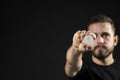 Successful business man in black t-shirt with ethereum coin isolated on grey background in studio with copy space. Hold