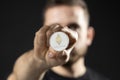 Successful business man in black t-shirt with ethereum coin isolated on grey background in studio. Hold ethereum