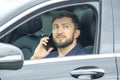 Successful business man with a phone in his hand sits behind the wheel of a prestigious car Royalty Free Stock Photo