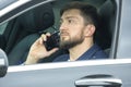 Successful business man with a phone in his hand sits behind the wheel of a prestigious car Royalty Free Stock Photo