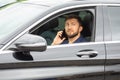 Successful business man with a phone in his hand sits behind the wheel of a prestigious car Royalty Free Stock Photo