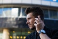 Confident male entrepreneur calling via smartphone, standing outside Royalty Free Stock Photo