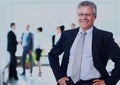 Successful business man standing with his staff in background at office. Royalty Free Stock Photo