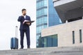 Successful business man stands on the steps against the background of an office building with documents in his hands Royalty Free Stock Photo