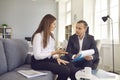 Business partners discussing a new business project while sitting on a sofa in the office. Royalty Free Stock Photo