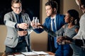 Business people clinking glasses and smiling while celebrating in meeting Royalty Free Stock Photo