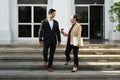 Successful business people having a nice conversation each other and walking down stairs of modern office building Royalty Free Stock Photo