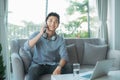 Successful Business Talk. Man Talking On Cellphone Using Laptop Sitting On Sofa Indoor. Copy Space Royalty Free Stock Photo