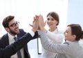 Successful business team giving each other a high-five, standing in the office Royalty Free Stock Photo