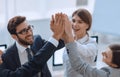 Successful business team giving each other a high-five, standing in the office Royalty Free Stock Photo