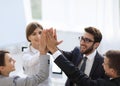 Successful business team giving each other a high-five, standing in the office Royalty Free Stock Photo