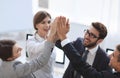 Successful business team giving each other a high-five, standing in the office Royalty Free Stock Photo