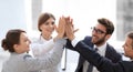 Successful business team giving each other a high-five, standing in the office Royalty Free Stock Photo