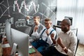 Successful business team. Three stock traders looking at graphs, indexes and numbers on multiple computer screens Royalty Free Stock Photo