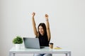 Successful young business woman with arms up at the office Royalty Free Stock Photo